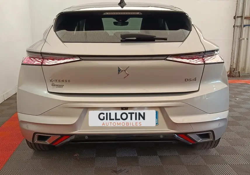 Vue arrière d'une DS4 E-TENSE 225 gris clair avec feux LED étirés et double sortie d'échappement intégrée.