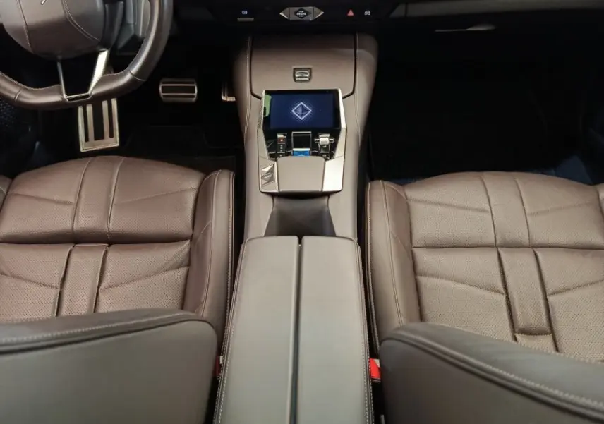 Vue intérieure du poste de conduite du DS4 E-TENSE 225 gris clair, avec tableau de bord numérique et console centrale tactile.