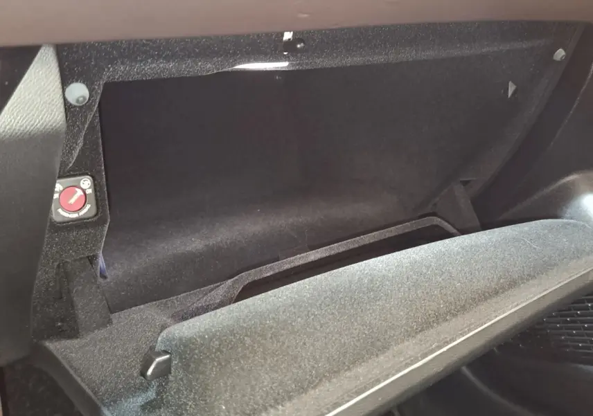 Gant de boîte à gants ouvert en tissu noir dans l'habitacle de la DS4 E-TENSE 225 gris clair, vue intérieure côté passager.
