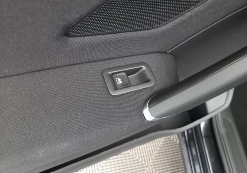 Détail de la commande de vitre électrique sur la porte intérieure côté gauche d’un Volkswagen Touran noir 2024.