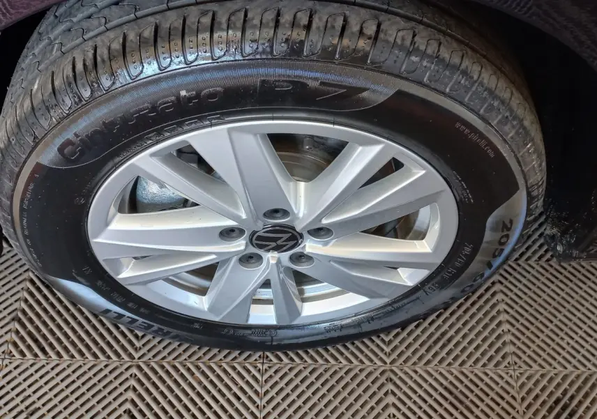 Gros plan sur la roue avant droite du Volkswagen Touran noir 2024 avec jante alliage argentée et pneu Pirelli.