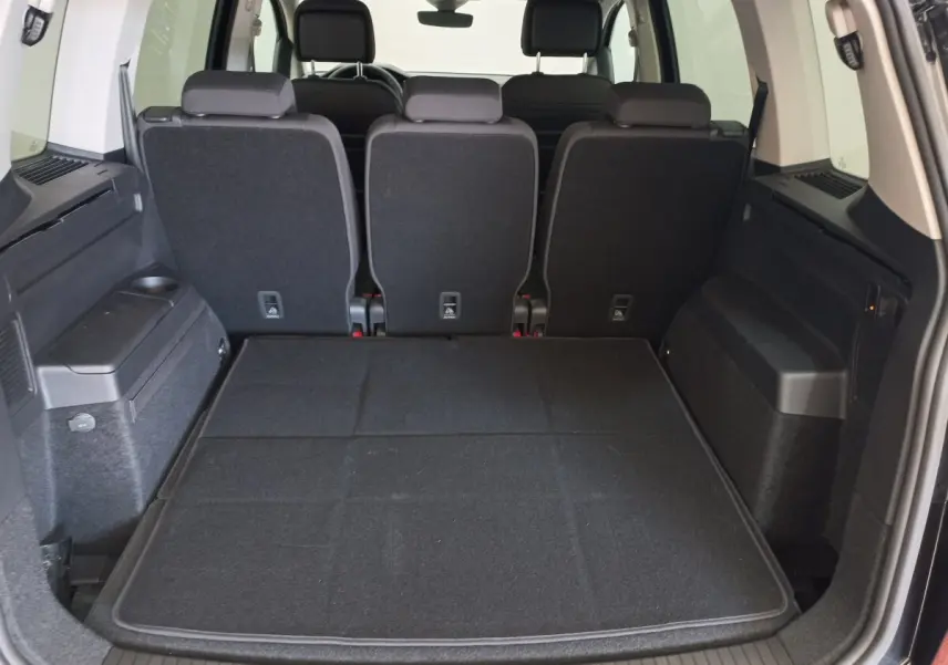 Vue arrière du coffre noir du Volkswagen Touran 2024 avec sièges arrière en position verticale et plancher plat.