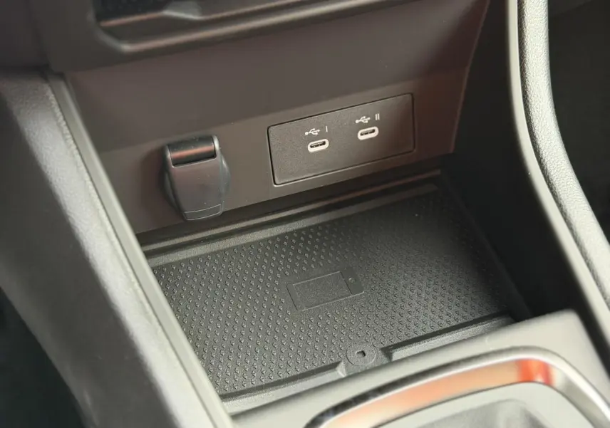 Gros plan sur la console centrale du Renault Captur 2025, montrant les prises USB-C et le chargeur sans fil.