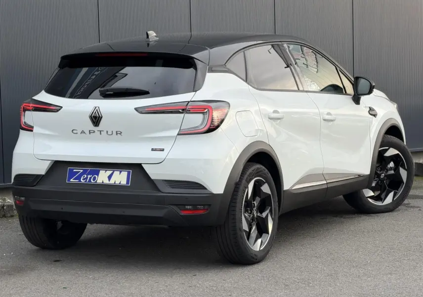 Vue 3/4 arrière droite du Renault Captur blanc nacré et noir étoile avec jantes aluminium 18 pouces et toit noir.