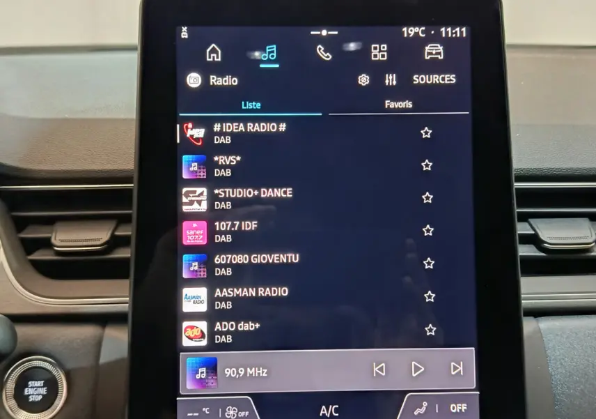 Écran tactile central affichant la radio dans l'habitacle du Renault Captur blanc, vue rapprochée du tableau de bord.