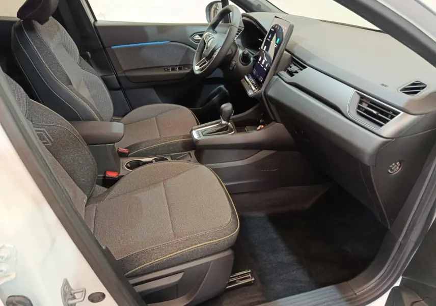 Vue intérieure côté passager du Renault Captur blanc 2025, avec tableau de bord moderne et écran tactile vertical.