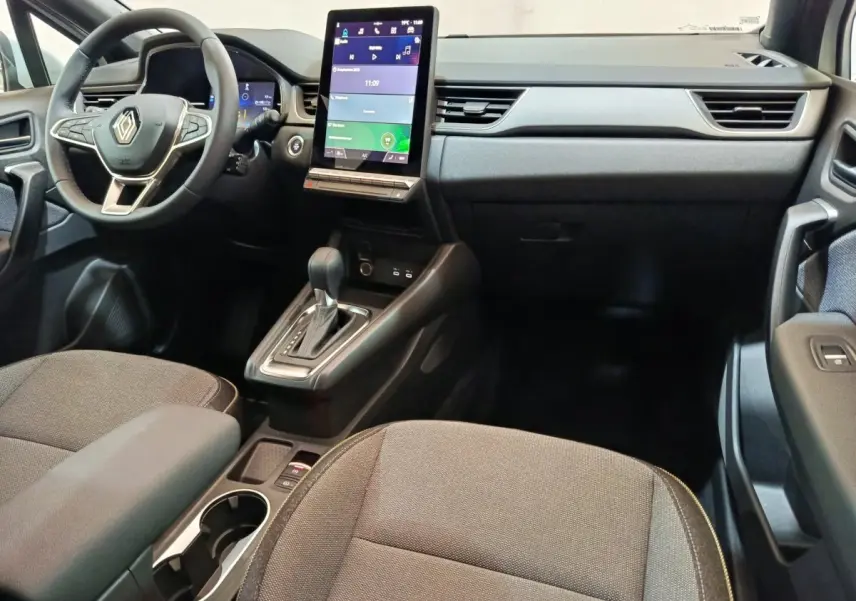 Intérieur du Renault Captur Techno E-Tech 2025, vue avant centrée sur tableau de bord et écran tactile vertical.