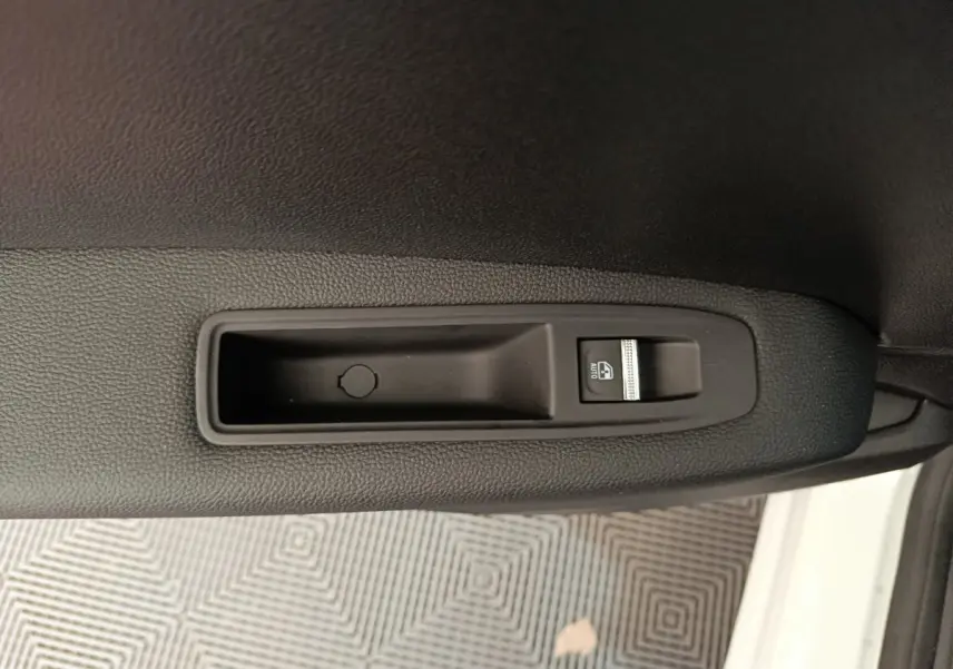 Gros plan sur la commande de lève-vitre côté droit du Renault Captur blanc, finition techno E-Tech hybride.