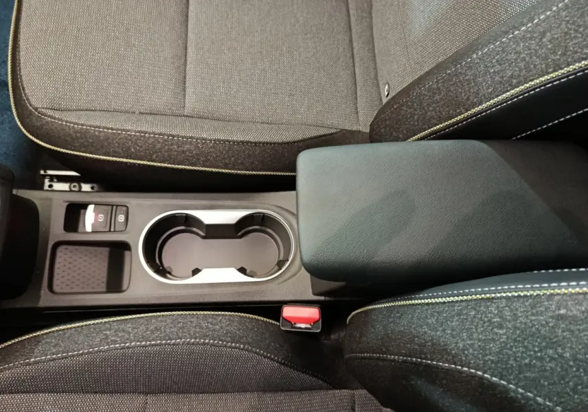 Vue rapprochée de la console centrale et des sièges gris avec surpiqûres jaunes du Renault Captur Techno E-Tech 2025.