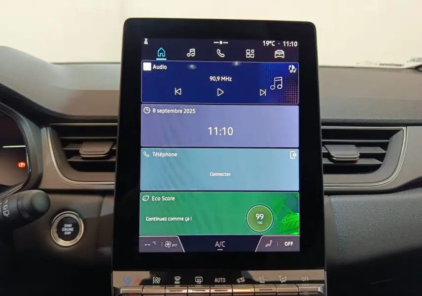 Vue rapprochée du tableau de bord central tactile du Renault Captur blanc 2025, affichant l'interface multimédia.