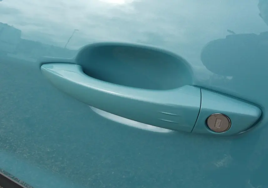 Poignée de porte avant droite bleu métallisé du Jeep Avenger 2024 avec serrure intégrée.