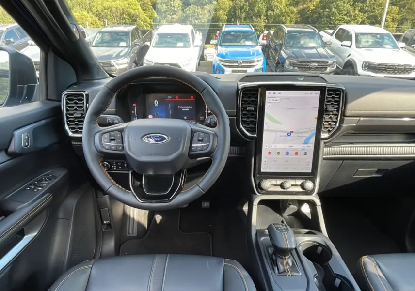 Vue intérieure avant du Ford Ranger 2025 bleu lightning, mettant en valeur le volant cuir et l'écran tactile vertical.