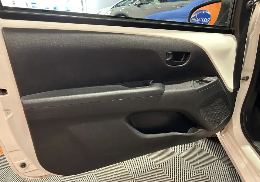 Vue intérieure de la porte avant gauche blanche d'une Peugeot 108 2014, avec panneau noir et commandes de fenêtre.
