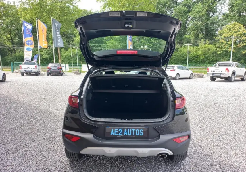 Vue arrière d’un KIA STONIC noir 2025 avec coffre ouvert, mettant en valeur son hayon et son pare-chocs gris.