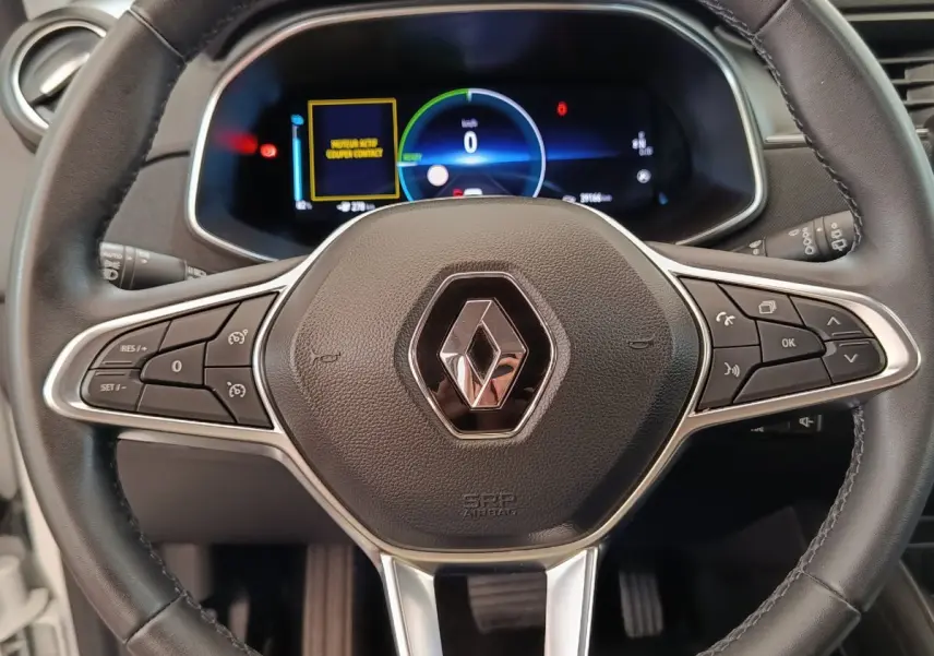 Vue rapprochée du volant cuir noir multifonctions de la Renault ZOE Business Rev R110 blanc, avec tableau de bord digital.