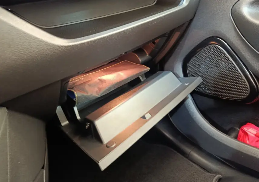 Vue intérieure côté passager montrant la boîte à gants ouverte et le rangement sous siège dans une Renault ZOE blanche 2021.