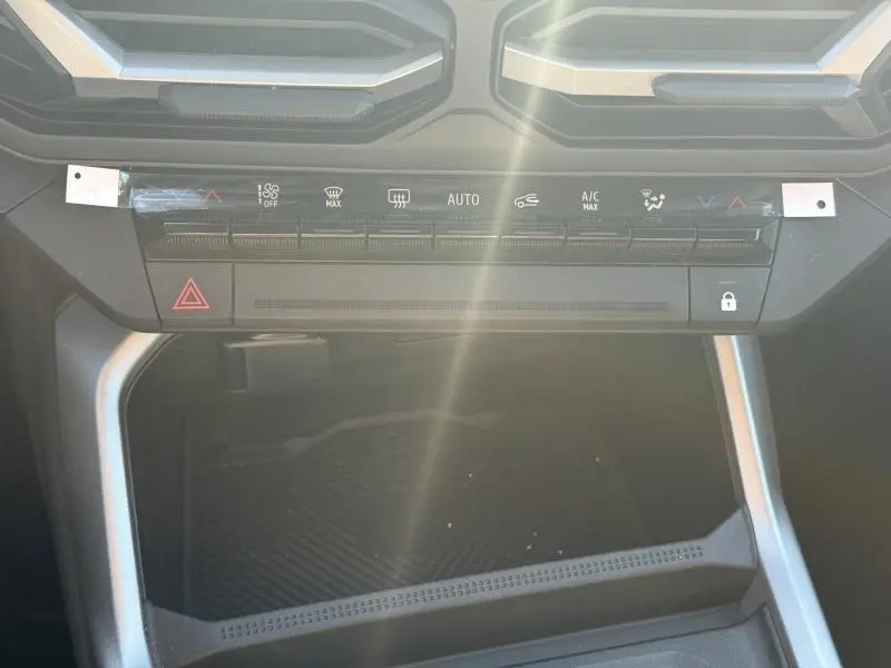Vue rapprochée de la console centrale noire du Dacia Bigster 2025 avec commandes climatisation et bouton verrouillage.