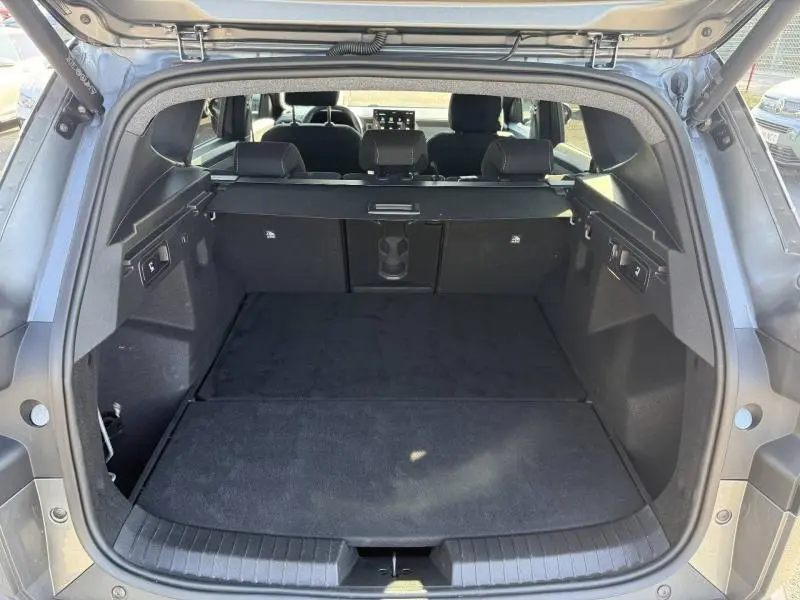 Coffre ouvert vu de l'arrière du Dacia Bigster gris schiste, montrant un espace de chargement spacieux et modulable.