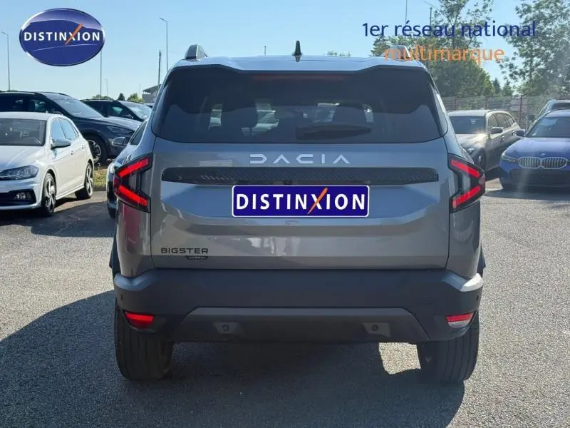 Vue arrière du Dacia Bigster gris schiste 2025 avec feux LED en forme de C et logo DACIA lumineux.