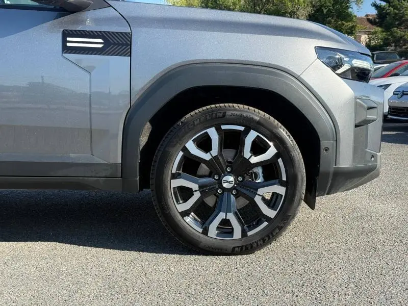 Gros plan sur la roue avant droite du Dacia Bigster gris schiste, avec jante alu et partie avant du véhicule visible.