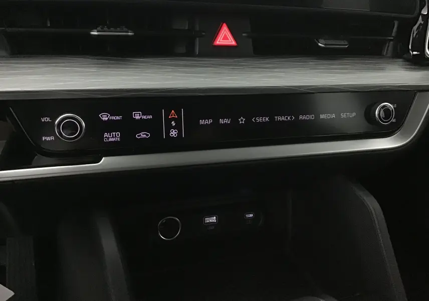 Tableau de bord du Kia Sportage vert Borneo 2025, vue rapprochée sur la console centrale avec commandes tactiles et ports USB.