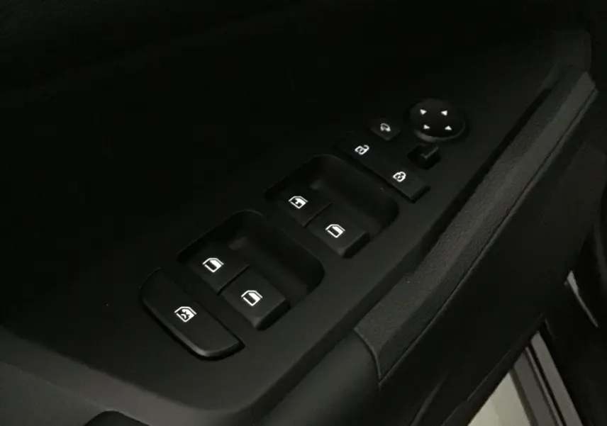 Gros plan sur les commandes des vitres et rétroviseurs côté gauche du Kia Sportage 2025, intérieur noir.