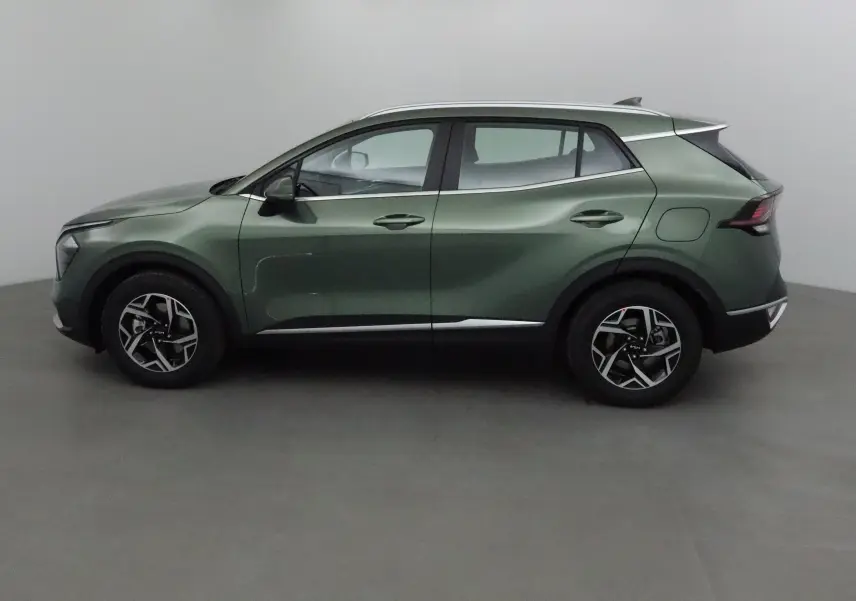 Profil côté gauche du Kia Sportage 2025 vert Borneo avec jantes alliage et lignes sculptées modernes.
