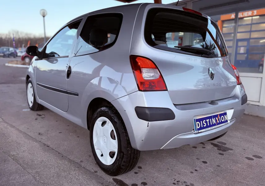 Vue 3/4 arrière gauche d'une Renault Twingo II gris clair avec jantes blanches et pare-chocs noirs.