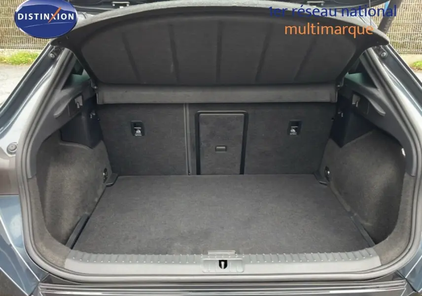 Coffre ouvert vu de l'arrière d'une CUPRA Formentor gris magnétique métal, montrant un espace de chargement propre et spacieux.