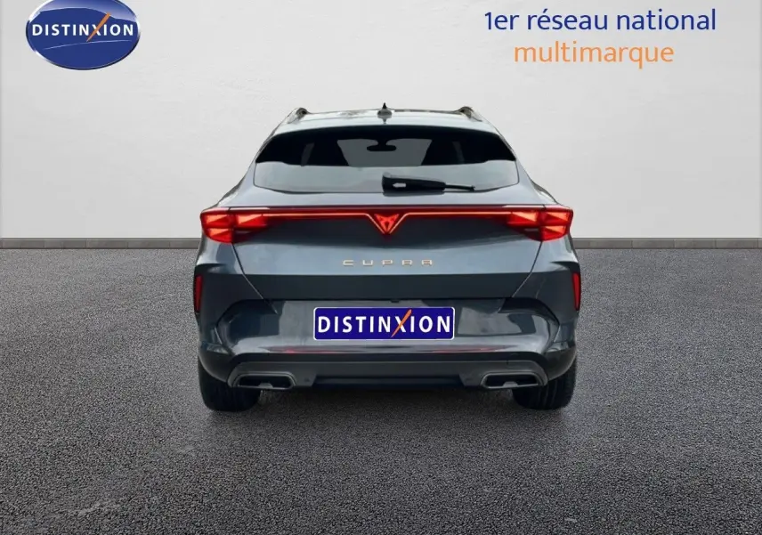 Vue arrière d'une CUPRA Formentor 1.5 eTSI 150CH DSG7 en gris magnétique métal avec feux arrière LED allumés.