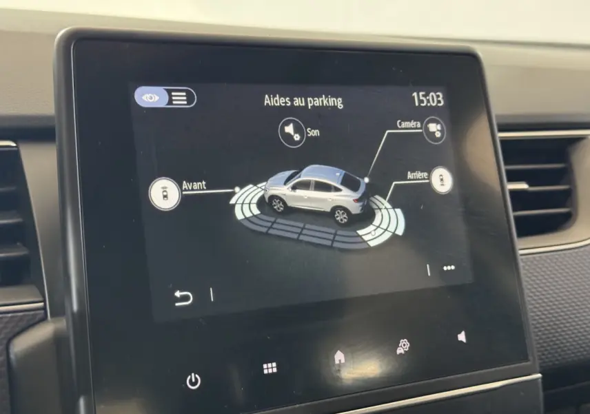 Écran tactile intérieur montrant l'aide au stationnement avec vue 3D d'un Renault Arkana gris foncé en plan rapproché.