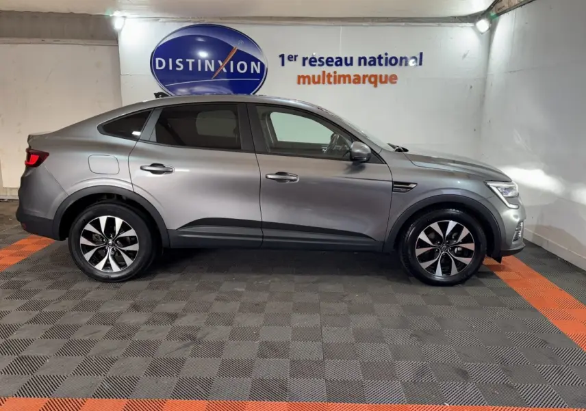 Profil côté gauche d'un Renault Arkana Business E-TECH 145 gris foncé, SUV hybride avec jantes alliage et lignes fluides.