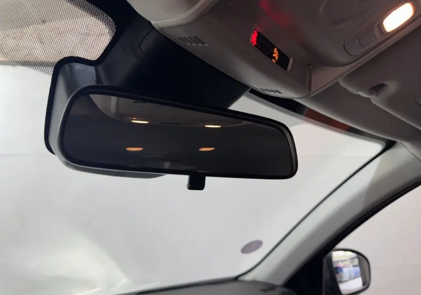 Vue intérieure centrée sur le rétroviseur intérieur du Renault Arkana Business E-TECH gris foncé, avec partie du pare-brise et rétroviseur latéral droit visible.