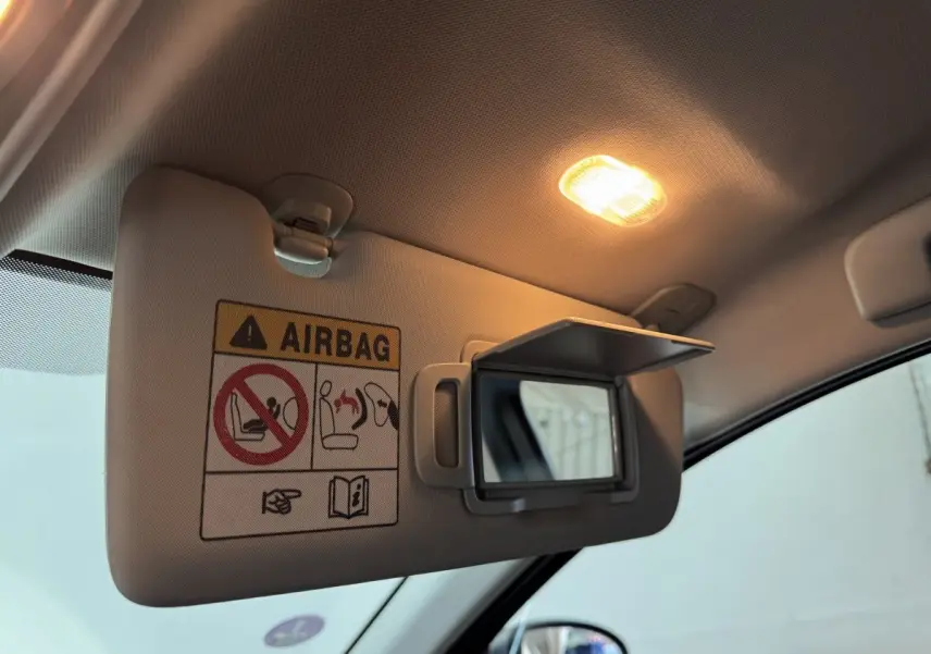 Détail du pare-soleil côté conducteur avec miroir et avertissement airbag dans un Renault Arkana gris foncé 2022.