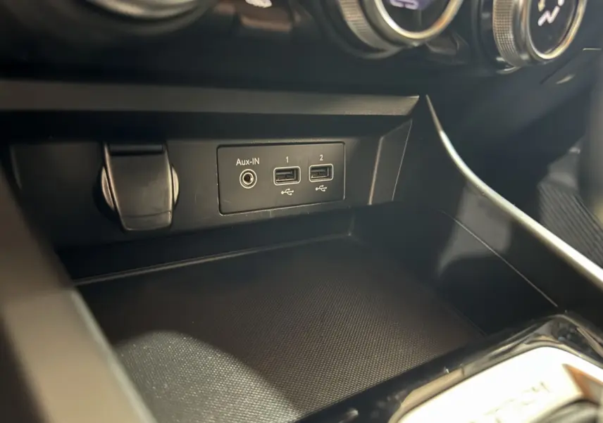 Gros plan sur la console centrale du Renault Arkana Business E-TECH 145, montrant les ports USB et prise Aux-In.