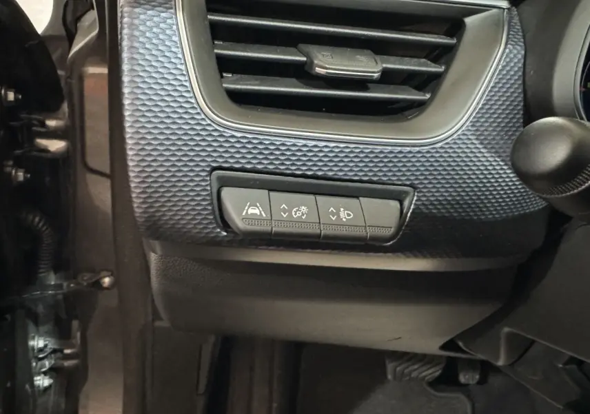 Détail intérieur du tableau de bord côté gauche du Renault Arkana gris foncé, avec commandes d'assistance à la conduite.