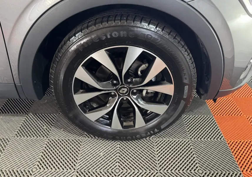 Gros plan sur la roue avant droite gris foncé d’un Renault Arkana Business E-TECH 145 avec jante alliage bicolore.