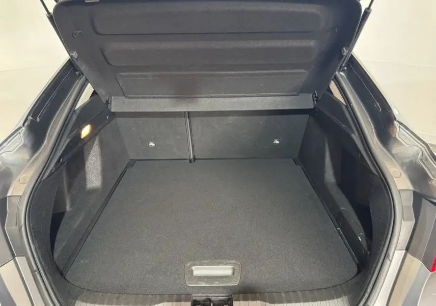 Coffre ouvert vu de l'arrière d'un Renault Arkana Business E-TECH gris foncé, espace de chargement vide et propre.