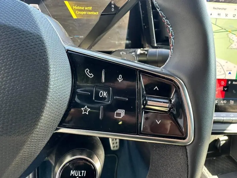 Gros plan sur les commandes au volant côté gauche du Renault Rafale bleu, avec écran tactile et détails du tableau de bord visibles.