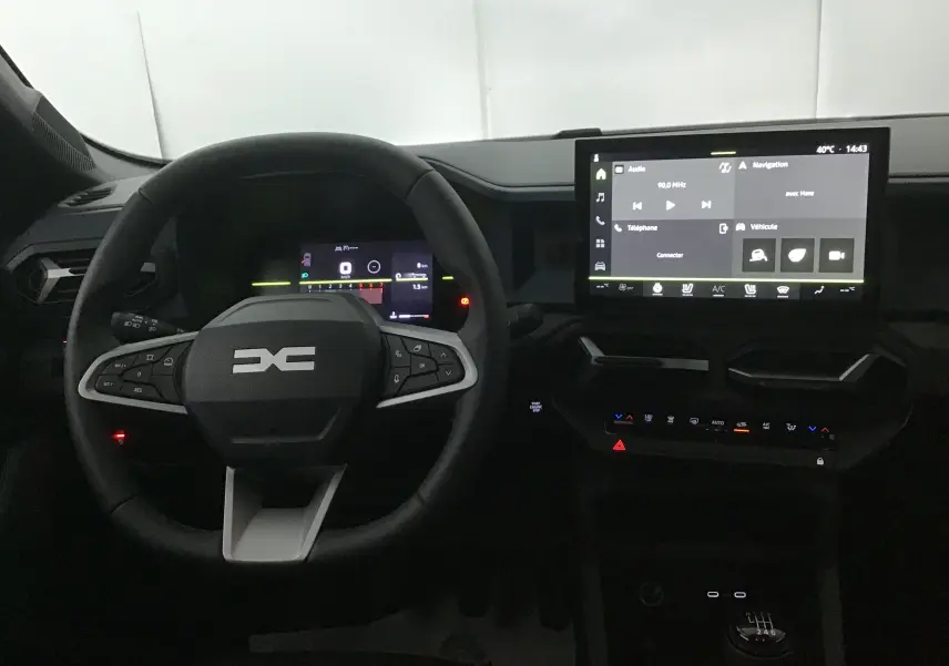 Vue intérieure du tableau de bord et volant noir du Dacia Bigster 2025 avec écran tactile et boîte manuelle visible.