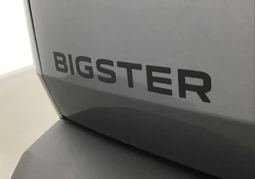 Gros plan sur l'inscription BIGSTER en noir sur la carrosserie gris schiste du Dacia Bigster 2025.