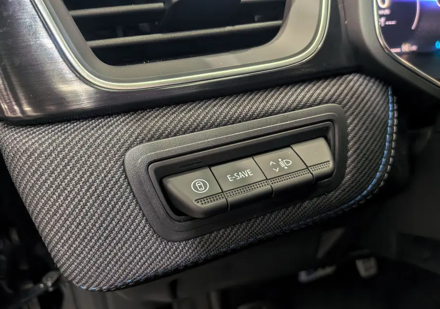 Gros plan sur les commandes E-SAVE et réglage des phares dans l'habitacle du Renault Captur noir étoilé 2025 esprit Alpine.