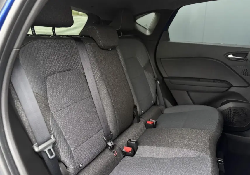 Vue latérale intérieure des sièges arrière gris foncé du Renault Captur 2025, avec ceinture de sécurité et porte côté droit visible.
