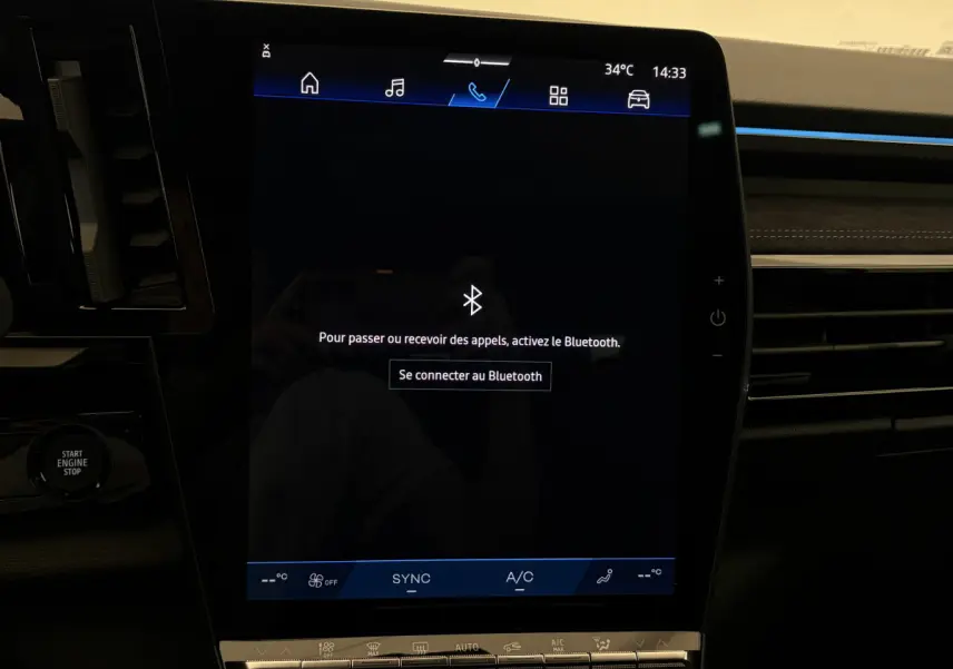 Écran tactile central du tableau de bord du Renault Espace blanc, affichant la connexion Bluetooth, intérieur moderne noir.