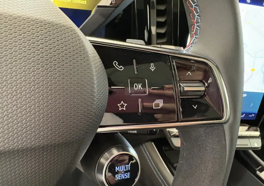 Gros plan sur le volant cuir-suède avec commandes multifonctions et écran tactile du tableau de bord du Renault Espace blanc 2025.