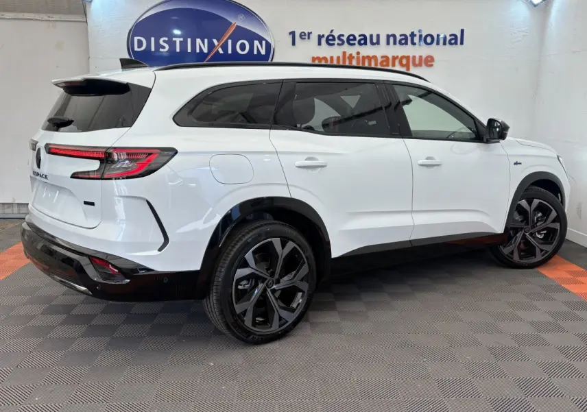 Vue 3/4 arrière droite du Renault Espace Esprit Alpine blanc, avec jantes noires et feux arrière LED allumés.