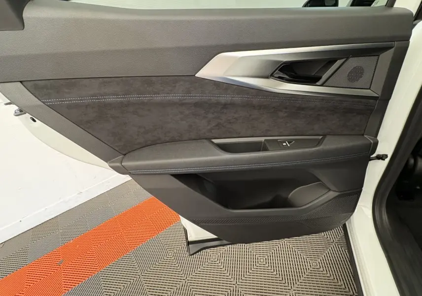 Vue intérieure côté gauche de la porte avant blanche du Renault Espace esprit Alpine avec garniture noire et surpiqûres bleues.