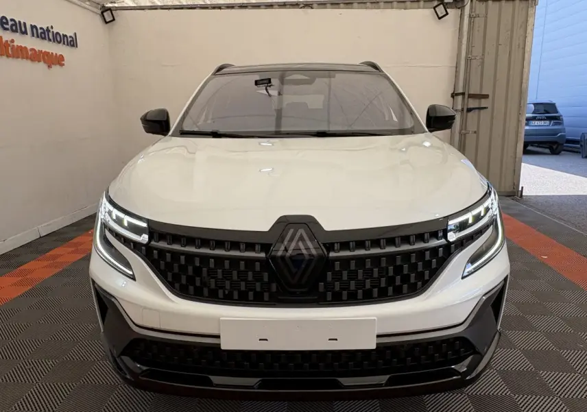 Vue avant d'un Renault Espace blanc esprit Alpine 7 places avec calandre noire et feux LED distinctifs dans un garage.