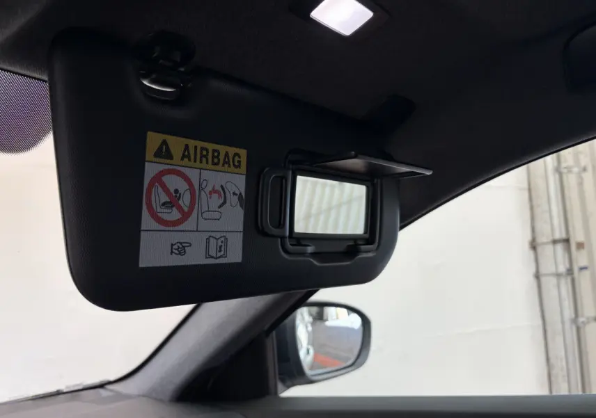 Détail intérieur du pare-soleil côté conducteur avec miroir et avertissement airbag dans un Renault Espace blanc 2025.
