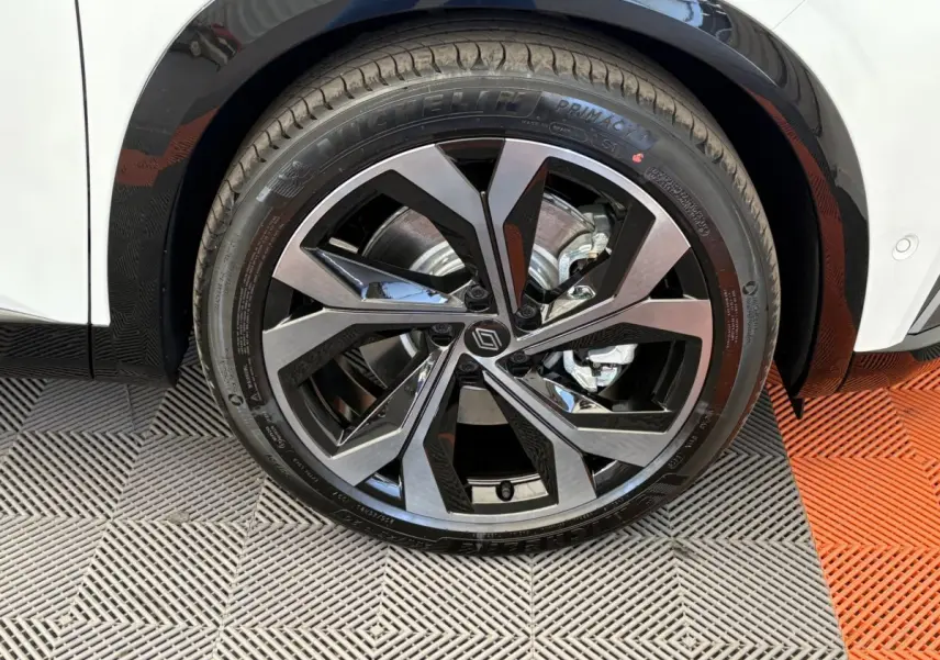 Gros plan sur la roue avant droite du Renault Espace blanc, jante alliage noire et argentée au design moderne.